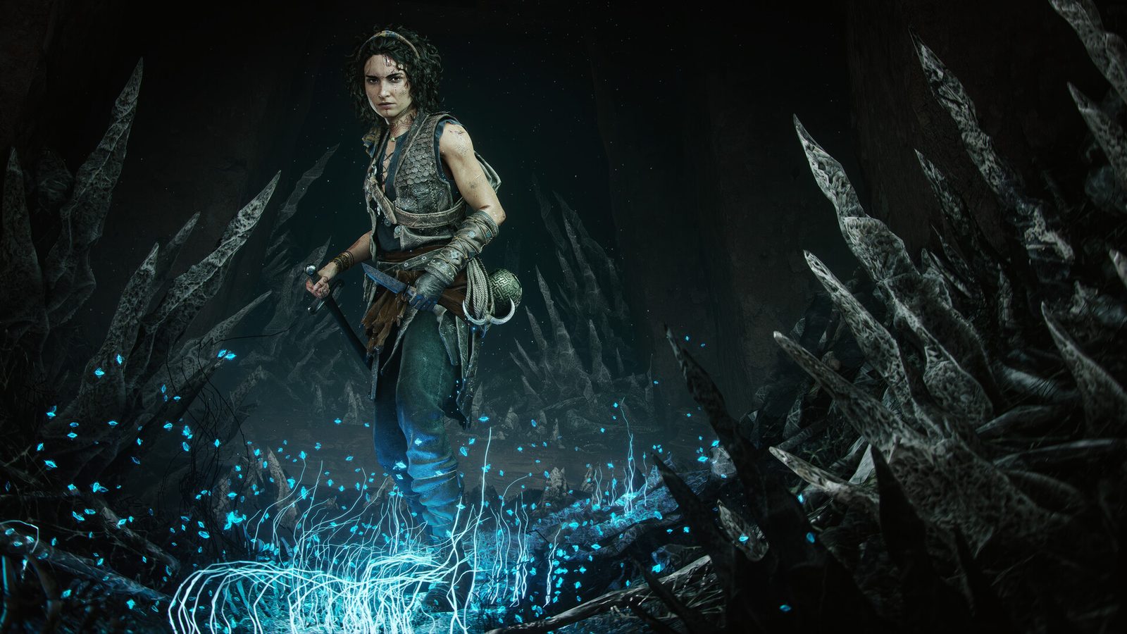 Sophia faces the camera with a curved sword in one hand and the Minoan sphere on her belt while blue Macula light rises around her boots inside a spiked cavern.